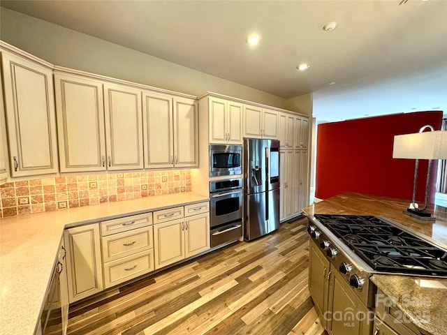 255 Charlotte Ann Ln, Hickory, NC 28601 - kitchen with decorative backsplash, light wood-type flooring, a warming drawer, cream cabinets, and appliances with stainless steel finishes