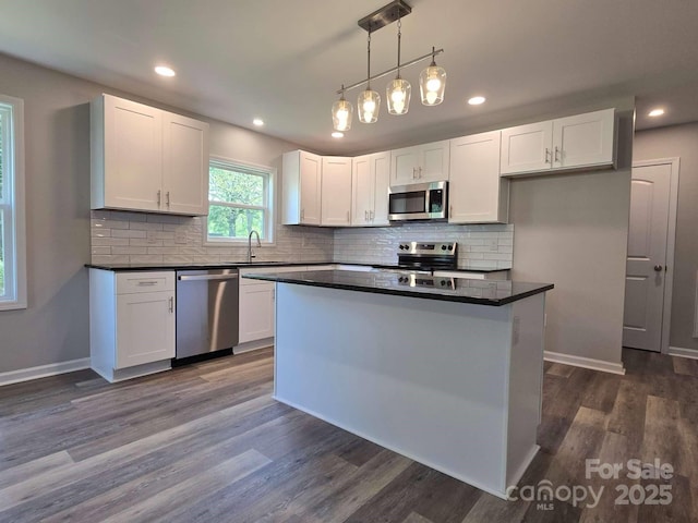 kitchen featuring white cabinets, dark countertops, and stainless steel appliances
