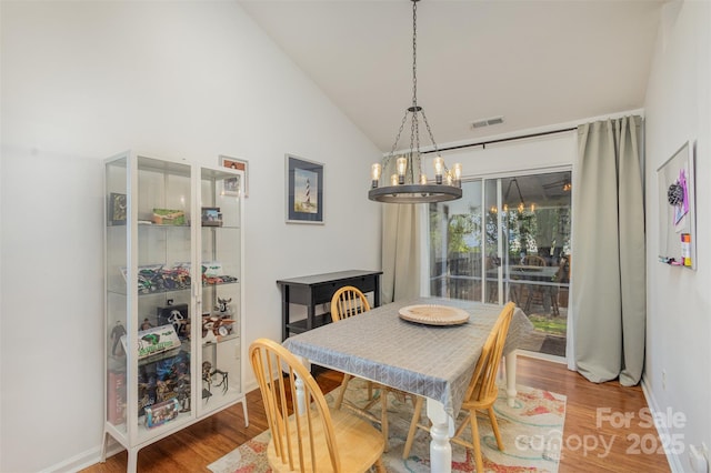 5804 Crosswinds Ct, Indian Trail, NC 28079 - dining room featuring a chandelier, wood finished floors, baseboards, and high vaulted ceiling