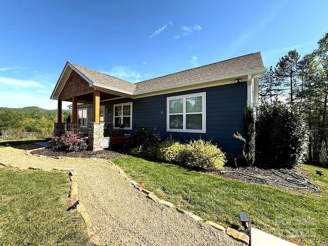 view of front of home with covered porch and a front lawn