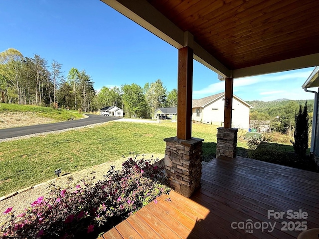 wooden terrace featuring a lawn