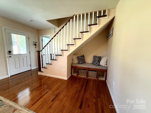entryway featuring stairway, baseboards, and wood finished floors