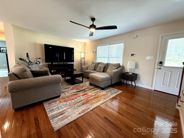living area featuring ceiling fan, plenty of natural light, baseboards, and hardwood / wood-style flooring
