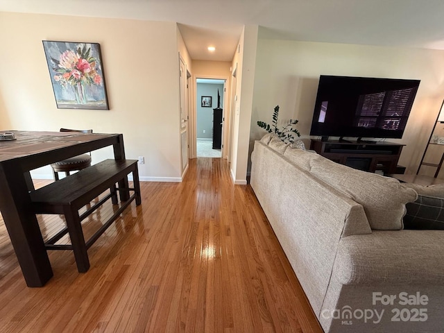 living room featuring recessed lighting, baseboards, and wood finished floors