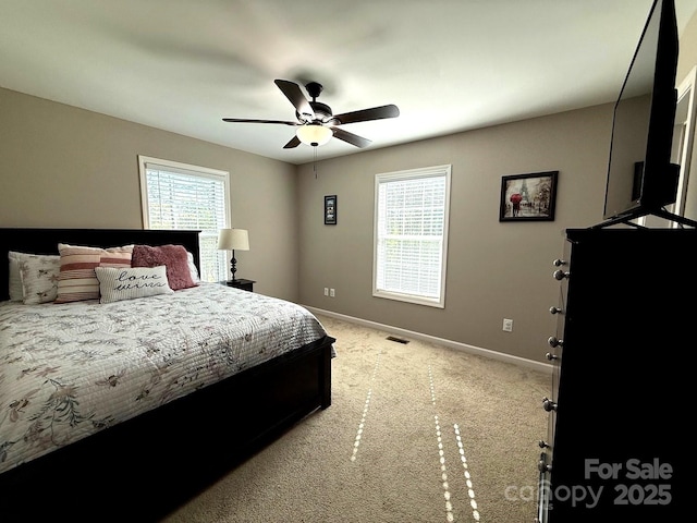 bedroom featuring baseboards, ceiling fan, light colored carpet, and visible vents