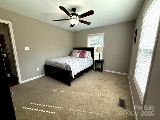 carpeted bedroom with baseboards, visible vents, and ceiling fan