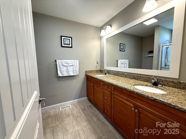 full bathroom with visible vents, a sink, baseboards, and double vanity