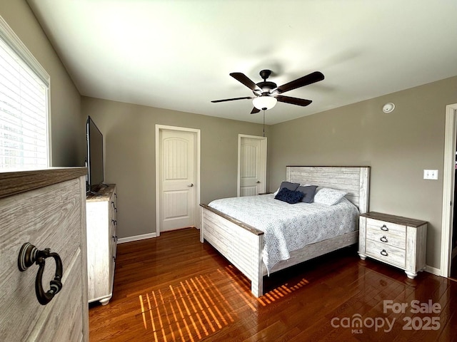 bedroom featuring baseboards, dark wood finished floors, and ceiling fan