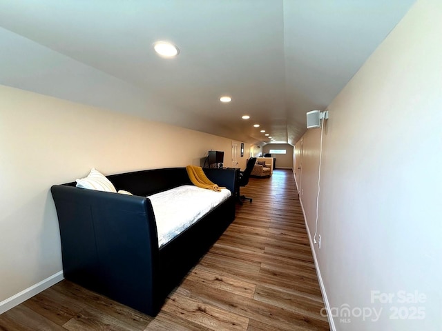 living room featuring recessed lighting, baseboards, wood finished floors, and lofted ceiling