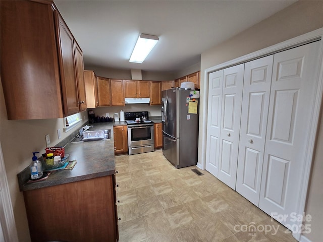 615 Tremont St, Troy, NC 27371 - kitchen featuring under cabinet range hood, stainless steel appliances, dark countertops, visible vents, and a sink