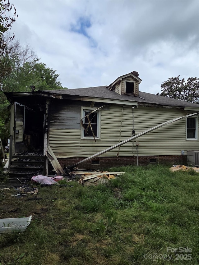 view of side of home with crawl space, cooling unit, and roof with shingles