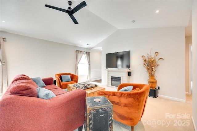living area featuring ceiling fan, light colored carpet, lofted ceiling, a glass covered fireplace, and recessed lighting