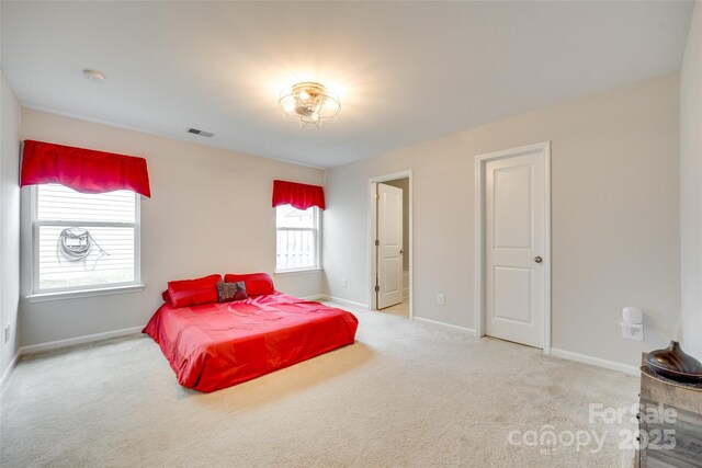 carpeted bedroom featuring baseboards and visible vents