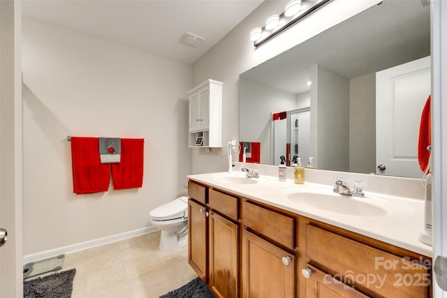 bathroom featuring a sink, baseboards, toilet, and double vanity