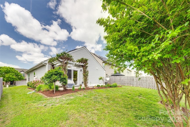 view of home's exterior featuring a lawn, a pergola, and fence