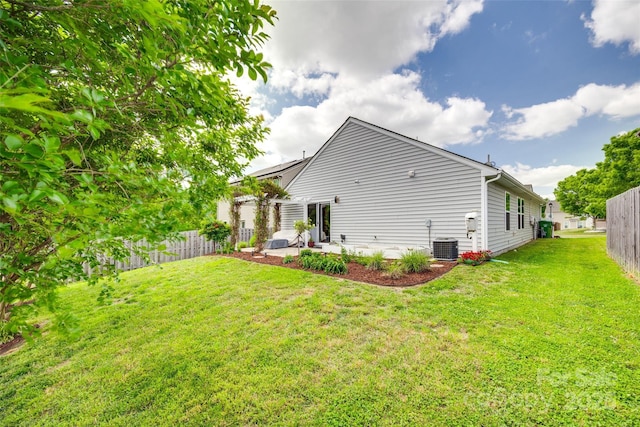 rear view of house featuring a fenced backyard, a yard, a patio area, and central AC