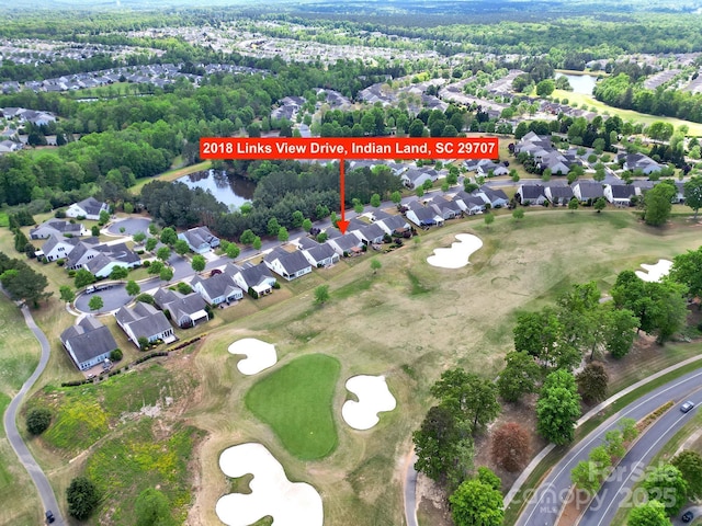 birds eye view of property with a water view, a residential view, and view of golf course