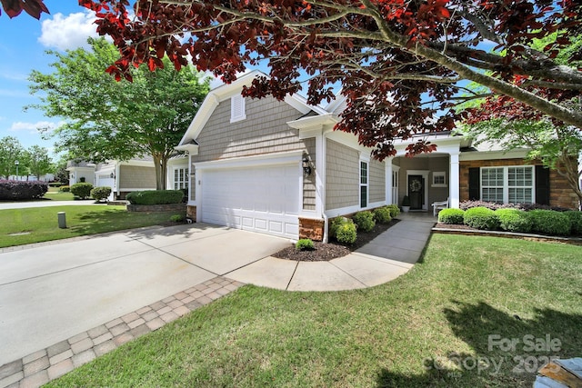 view of front of house featuring a front yard, driveway, stone siding, and a garage