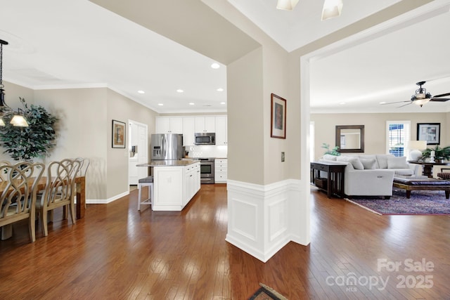 interior space with recessed lighting, ceiling fan, baseboards, ornamental molding, and dark wood finished floors