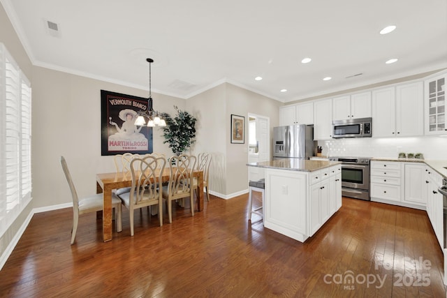 kitchen with glass insert cabinets, appliances with stainless steel finishes, a kitchen island, dark wood-style floors, and baseboards