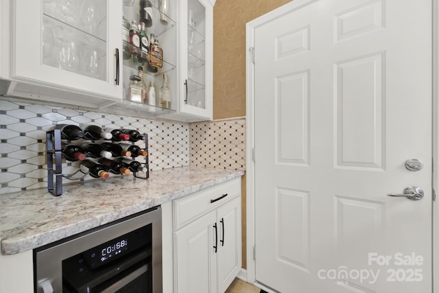 bar with wine cooler, decorative backsplash, and a bar