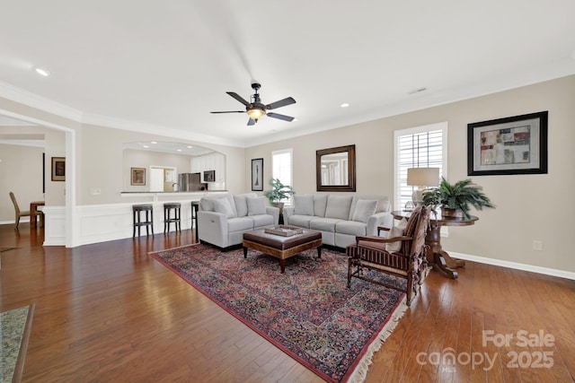 living room with ornamental molding, ceiling fan, hardwood / wood-style flooring, and arched walkways