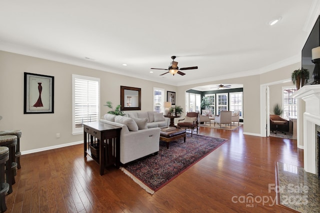 living room featuring recessed lighting, a fireplace with flush hearth, ceiling fan, dark wood-type flooring, and baseboards