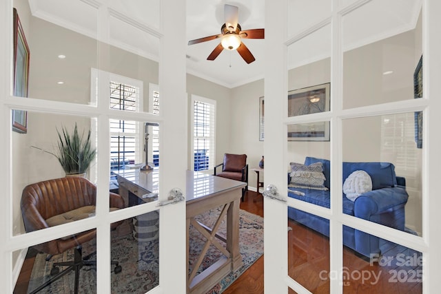 interior space with wood finished floors, ceiling fan, and ornamental molding