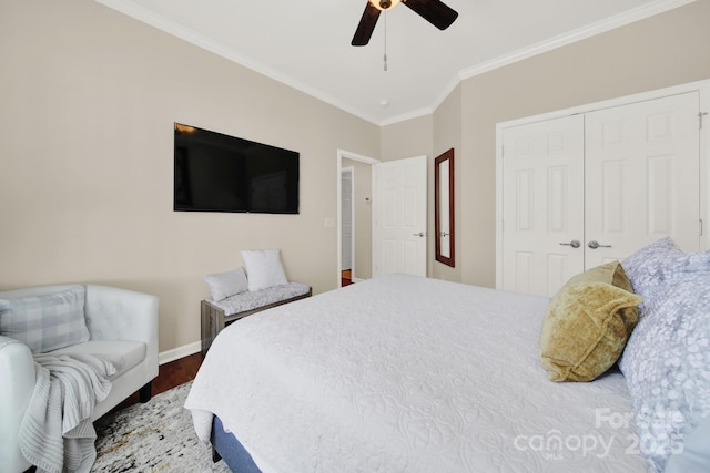 bedroom with wood finished floors, a closet, ornamental molding, baseboards, and a ceiling fan
