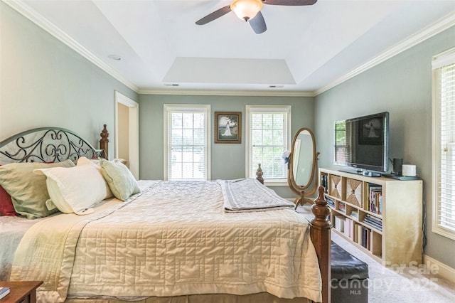carpeted bedroom featuring crown molding, a ceiling fan, a tray ceiling, and baseboards