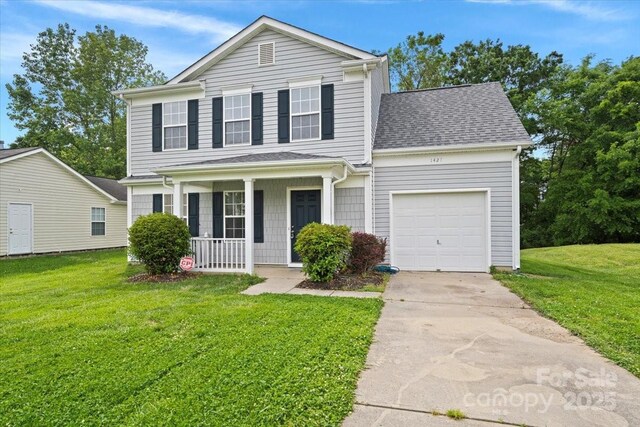 traditional-style house with a front yard, concrete driveway, a porch, and an attached garage