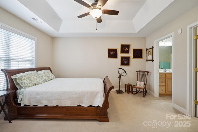 108 Ivy Ct, Morganton, NC 28655 - bedroom with light carpet, baseboards, connected bathroom, a tray ceiling, and a ceiling fan
