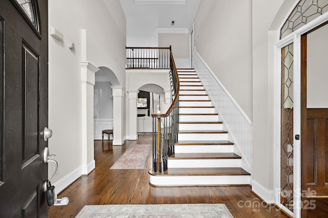 18730 Floyd Ct, Davidson, NC 28036 - entryway with decorative columns, arched walkways, wood finished floors, stairway, and a wainscoted wall
