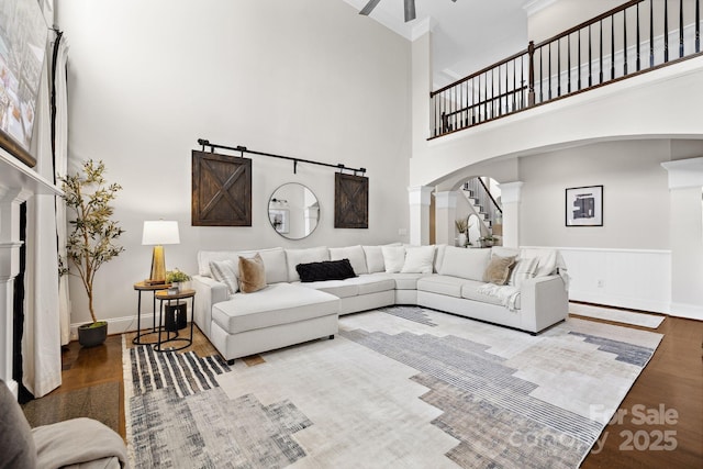 18730 Floyd Ct, Davidson, NC 28036 - living area featuring wood finished floors, arched walkways, a high ceiling, stairway, and baseboards