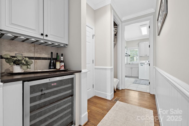 18730 Floyd Ct, Davidson, NC 28036 - indoor dry bar featuring beverage cooler, a wainscoted wall, light wood-type flooring, ornamental molding, and dishwashing machine