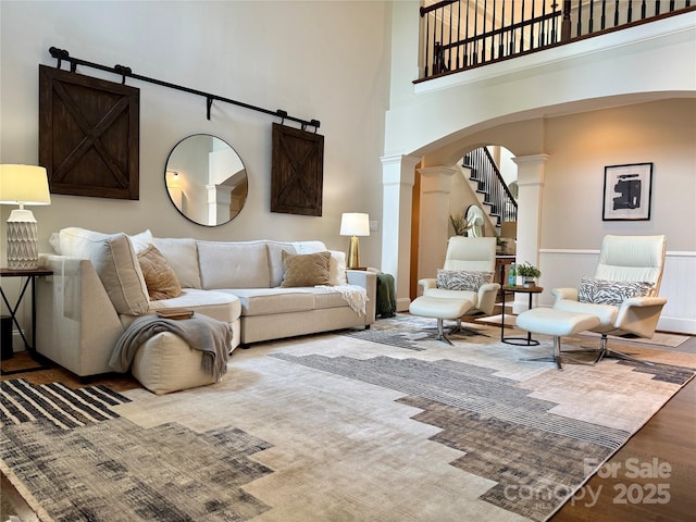 18730 Floyd Ct, Davidson, NC 28036 - living area with arched walkways, ornate columns, a high ceiling, and wood finished floors
