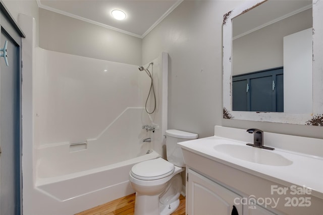full bathroom with crown molding, vanity, wood finished floors, toilet, and shower / washtub combination