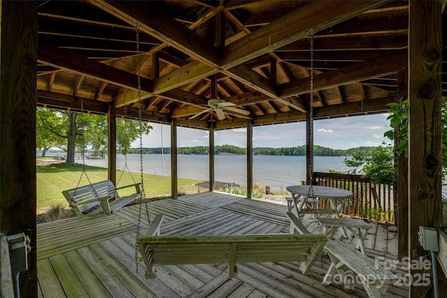 view of dock featuring a deck with water view and a yard