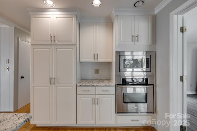 5200 Masons Ferry Rd, Clover, SC 29710 - kitchen featuring stainless steel appliances, white cabinetry, ornamental molding, tasteful backsplash, and light wood-type flooring
