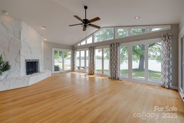 5200 Masons Ferry Rd, Clover, SC 29710 - unfurnished living room featuring a water view, wood finished floors, ceiling fan, a stone fireplace, and high vaulted ceiling