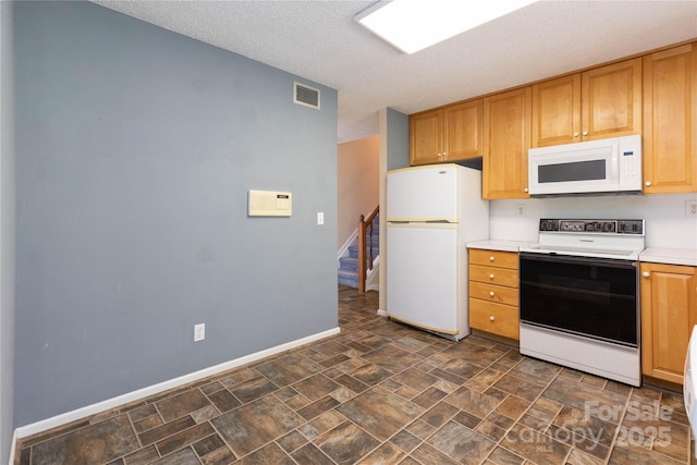 kitchen featuring light countertops, white appliances, a textured ceiling, and visible vents