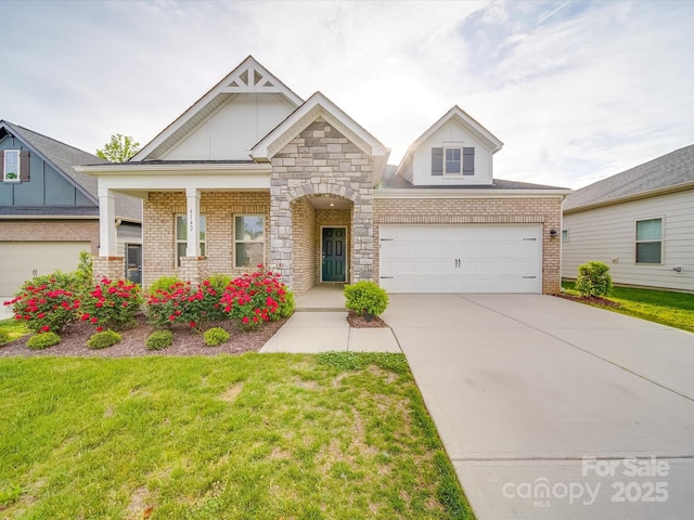 craftsman house with an attached garage, a front yard, driveway, and brick siding