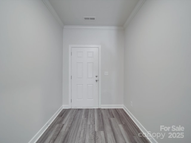 entryway featuring crown molding, baseboards, visible vents, and wood finished floors