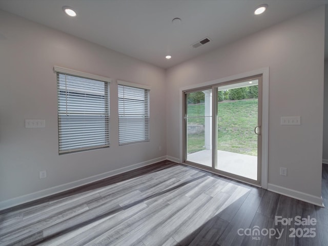unfurnished room featuring baseboards, recessed lighting, wood finished floors, and visible vents