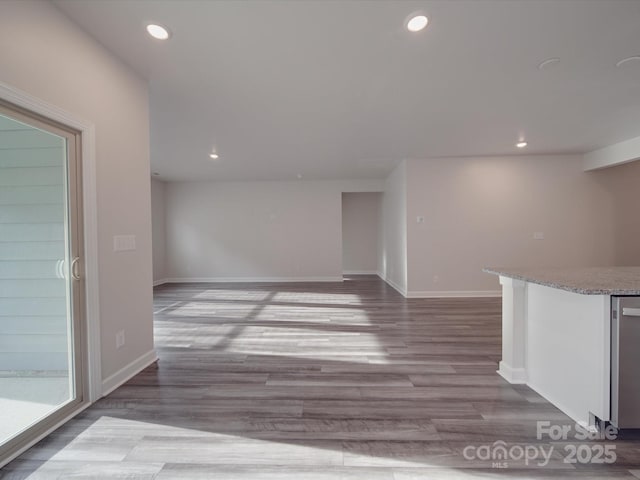 interior space featuring baseboards, bar, recessed lighting, and wood finished floors