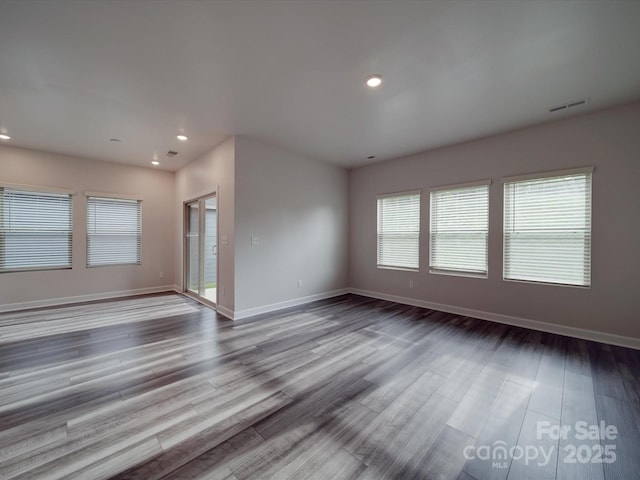 unfurnished living room with baseboards, recessed lighting, wood finished floors, and visible vents
