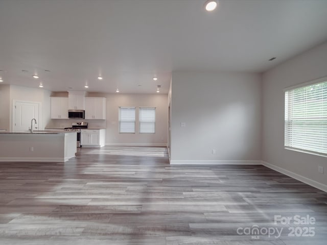 unfurnished living room featuring plenty of natural light, recessed lighting, and light wood-type flooring