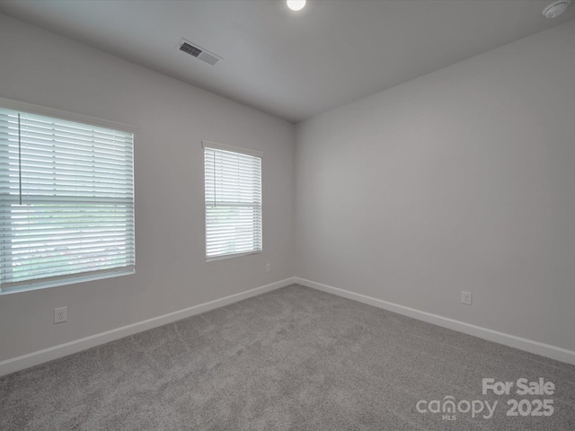 spare room with visible vents, carpet flooring, and baseboards