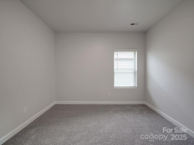 unfurnished room featuring baseboards, carpet, and visible vents
