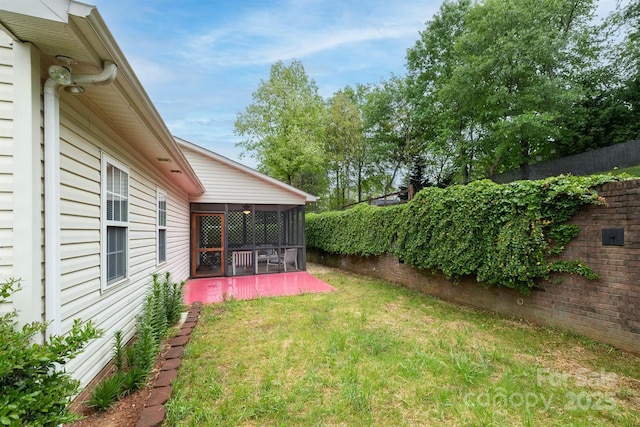 view of yard with fence, a patio area, and a sunroom